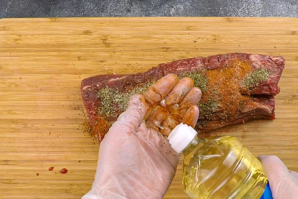 Затем обсыпать травами и паприкой, посолить по вкусу, добавить растительное масло. Распределить соль и специи равномерно со всех сторон, дать подмариноваться 5-7 минут.