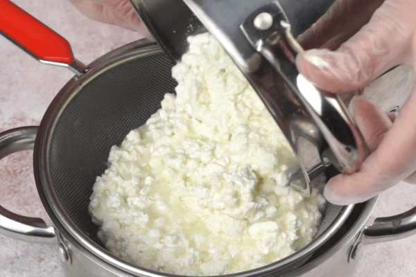 Процедить через мелкое сито или через дуршлаг, выстеленный марлей, чтобы удалить сыворотку. 