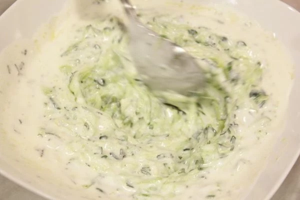 Смешать в чашке йогурт, огурцы, чеснок, нарезанные мяту и укроп, заправить по вкусу винным уксусом, оливковым маслом, солью, перцем. Поставить получившийся соус в холодильник на 20-30 минут.