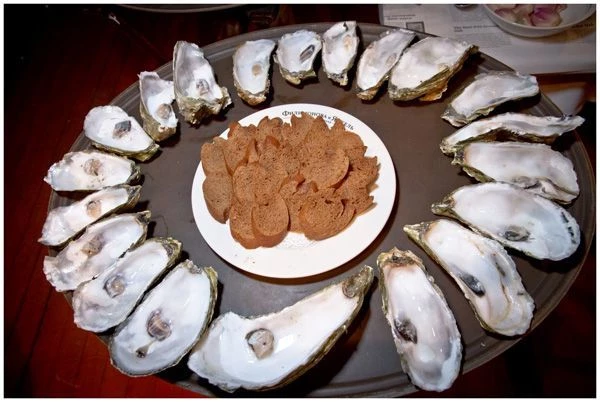 Открываем устрицы, достаем из них мясо и сливаем воду - сок, находящийся в раковине устрицы. Не выбрасывайте нижнюю створку раковины - она нам пригодится для сервировки