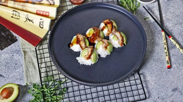 Аккуратно перевернуть лоток на тарелку. Красиво разложить суши. Полить соусом Унаги. Подавать с соевым соусом, имбирем и васаби. Приятного аппетита!

