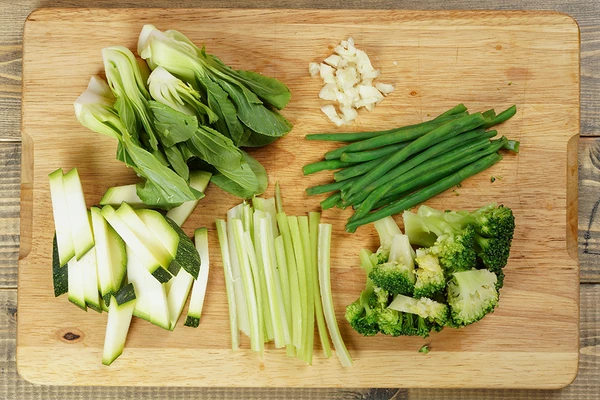 Нарезать сельдерей соломкой, кабачки брусочком, брокколи разрезать на соцветия, салат пак чой поделить на 2-3 части, чеснок мелко порубить.