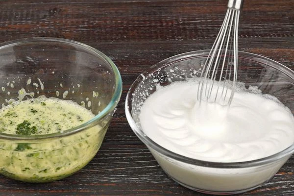 В белки добавить соль, взбить в густую пену. 