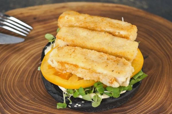 На микрозелень выложить нарезанные томаты и рыбные палочки. 