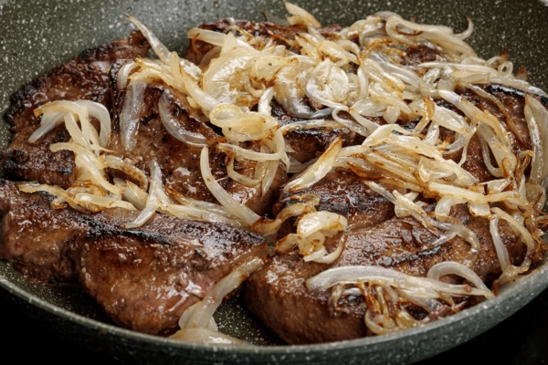 Обжаренный лук выложить на печень и снять с огня.