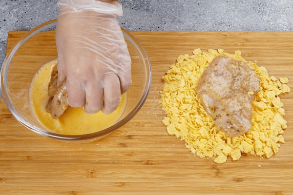 Стейки обвалять в яйце, затем запанировать в хлопьях.