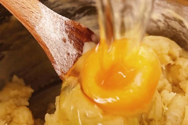 Снять с огня, немного охладить и по одному ввести 3 яйца, постоянно помешивая.