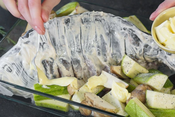 Разложить подготовленные овощи - топинамбур, кабачки, томаты- черри. Овощи посолить, выложить на них сливочное масло.