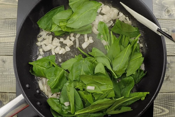 Затем добавить шпинат, перемешать и снять с огня, чтобы листики не успели пропитаться маслом.
