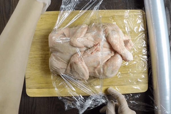 Фаршированную курицу завернуть в пищевую пленку или марлю, завязать кончики веревкой.