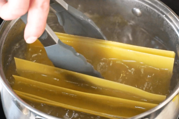 Листы лазаньи опустить в кипящую подсоленную воду на 5 минут. В воду можно добавить 1 ложку оливкового масла, чтобы предупредить склеивание листов теста. 