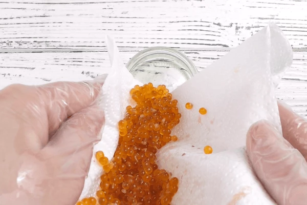 Методом перекатывания икры по тряпочке или полотенцу снимаем пустые оболочки зерен. 