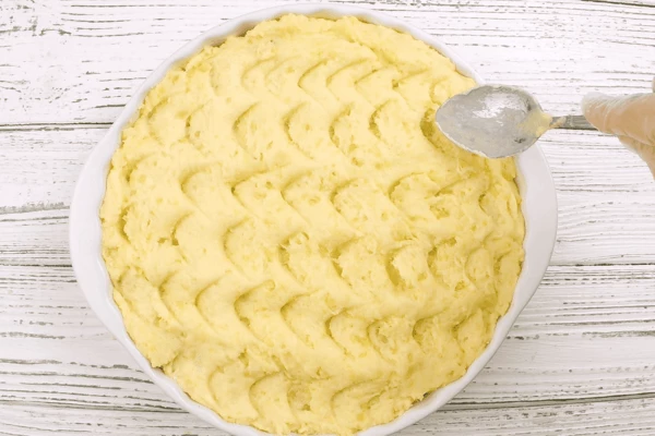 Сверху все закрыть картофельным пюре, с помощью ложки сделать узор и поставить в разогретую до 220С духовку на 2-3 минуты.