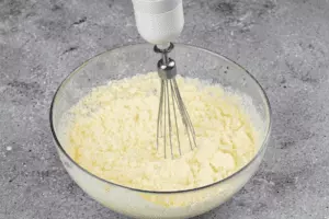  В чашке взбить яйца. Не переставая взбивать, добавить сливки, затем сыр и два вида масла. 