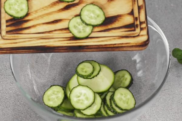 Цуккини и огурцы вымыть, нарезать кружочками. Переложить в салатник.