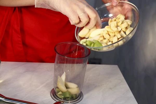 Фрукты очистите и нарежьте небольшими кусочками. Положите все чашу миксера.