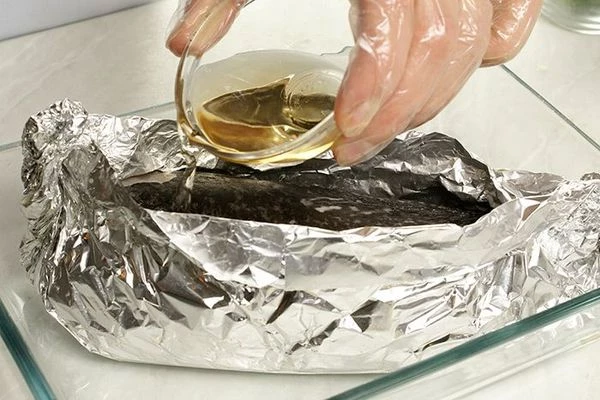 Переложить рулет на фольгу, закрепить края в виде "лодочки". Влить к рыбе белое вино. Поставить в разогретую до 220С духовку на 30 минут.