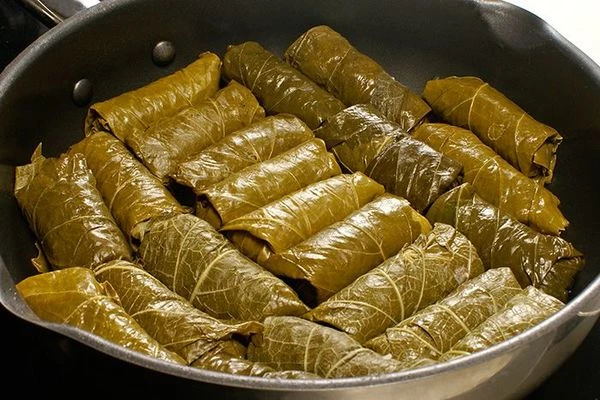 Выложить долму плотно на виноградные листья.