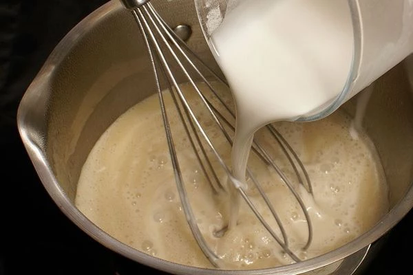 В горячее молоко влить крахмальную смесь, перемешать, прогреть до кипения 2-3 минуты до густоты. Снять с огня.