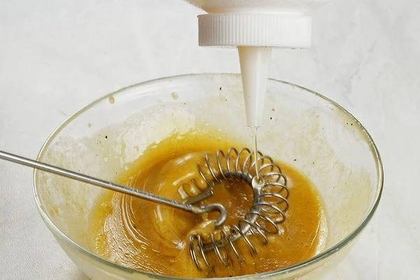 Тонкой струйкой влить растительное масло, не переставая взбивать.