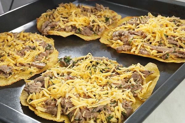 На противень выложить кукурузные лепешки, на них начинку.