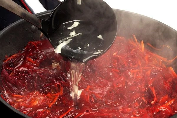 В заправку добавить свеклу, нарезанную соломкой и немного бульона. Потушить на медленном огне до полу готовности свеклы. 