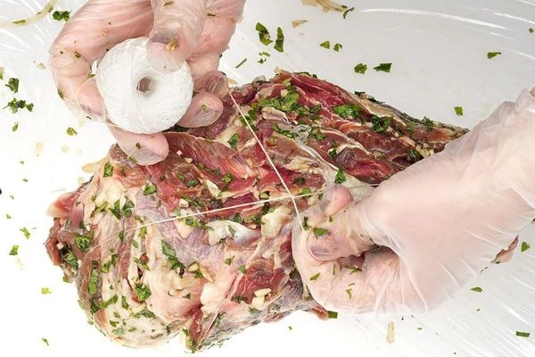 Замаринованную лопатку плотно обмотать кулинарным шпагатом (можно часть лука добавить для сочности в начинку). Переложить в пакет для запекания или завернуть в 2 слоя фольги. Уложить в форму для запекания, на дно которой налить примерно 1 стакан воды. Поставить в разогретую на 200С духовку на 2-2,5 часа. Минут за 10 до готовности можно пакет или фольгу разрезать, чтобы лопатка подрумянилась.