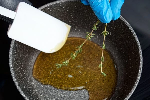 В небольшом сотейнике смешать уксус, мед и пару веточек тимьяна, довести до кипения и проварить примерно 2 минуты, затем перелить в чашку.