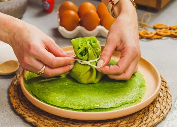 Собрать края вверх, завязать ниточкой сыра чечил. Повторить со всеми блинами. Приятного аппетита!