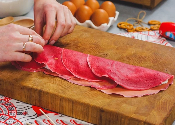 Сложить блинчики пополам и начать скручивать в рулет.