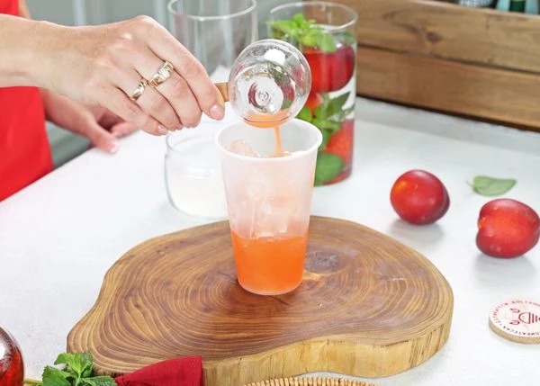 В стакан выложить лед. Налить сироп из нектаринов.