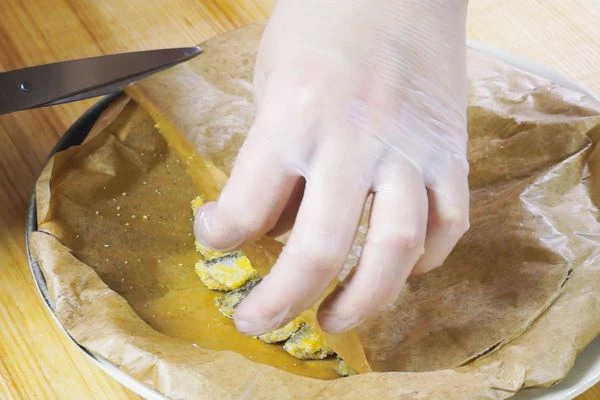 Готовую рыбу переложить на тарелку, снять пергамент, украсить лимоном, зеленью, посолить, поперчить по вкусу.