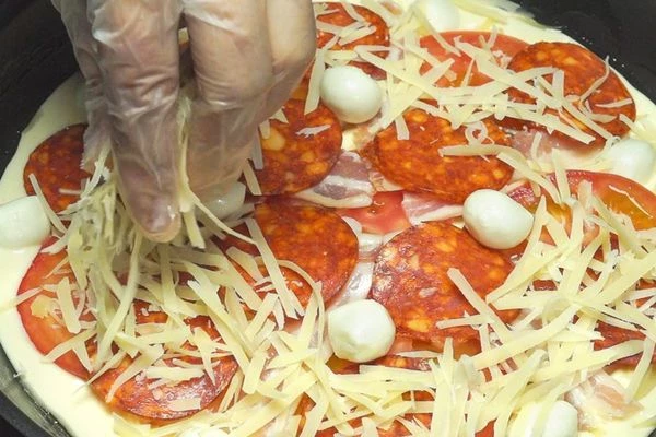 Выложить начинку (помидоры, лук репчатый, бекон и колбаса пепперони по вкусу, сыр твердый натертый на крупной терке, сыр моцарелла шарики – по вкусу).