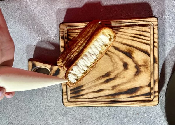 Творожный сыр переложить в кондитерский мешок. Отсадить творожный сыр в эклеры. 