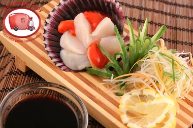 Раковину гребешка использовать для украшения. На украшенную смесью овощей тарелку выложить гребешок с лимоном. Рядом выложить цветочек из имбиря.