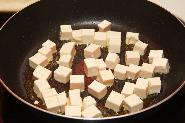 Нарезать творог тофу кубиками и обжарить их небольшом количестве кунжутного масла. Так же можно использовать уже готовый обжаренный тофу - инари.

