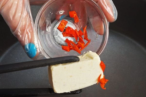 На разогретой сковороде с оливковым маслом, слегка обжарить мелко нарезанный перец чили.