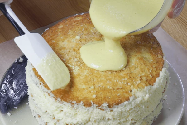 Обмазать края оставшейся начинкой. Оставшийся шоколад (100г) растопить в микроволновой печи, перемешать, украсить верх торта.