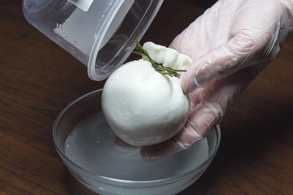 Сыр Буратта вынуть из рассола, удалить пластиковую веревку.