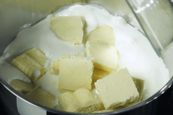  Сливки 200г влить в чистую кастрюльку, довести до кипения на среднем огне, добавить разломанный белый шоколад (мешать до растворения).