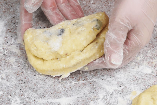 Раскатать в толстую лепешку, потом сложить внахлест.