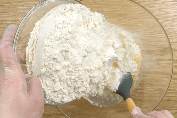 Всыпать муку, замесить тесто. Затем добавить цукатную смесь, обмять хорошо тесто, смазав немного растительным маслом. Поставить тесто в теплое место на 1 час.