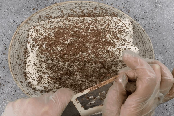 Сверху покрыть кремом, натереть горький шоколад и убрать в холодильник на 4-5 часов, чтобы торт пропитался (можно смело оставить на ночь).