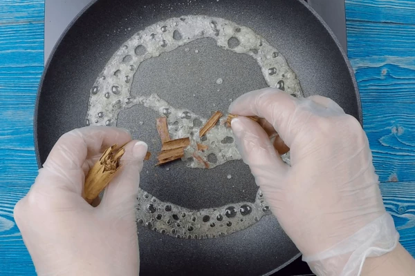 На разогретую сковороду добавить сахар, немного воды, уварить сахарный сироп. Можно добавить немного корицы.