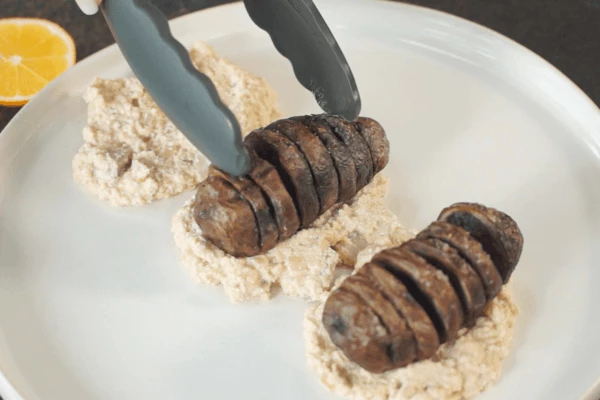 На блюдо для подачи выложить соус, затем запеченный картофель. 