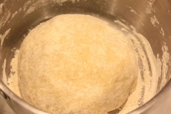 Соду загасить уксусом. В чашке смешать масло, горячую воду, муку. Замесить мягкое, не липнущее к рукам тесто.