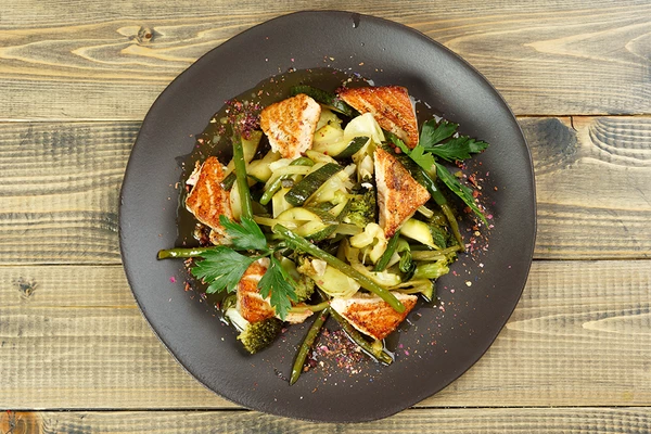 В центр тарелки выложить готовую овощную смесь, сверху украсить теплой рыбой.