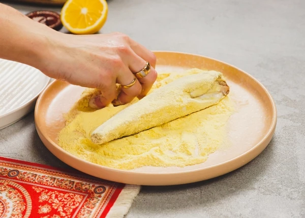 Посолить, обвалять в кукурузной муке. 