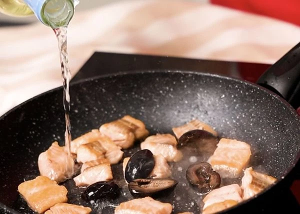 Добавить маслины и влить белое сухое вино. Выпарить вино. 