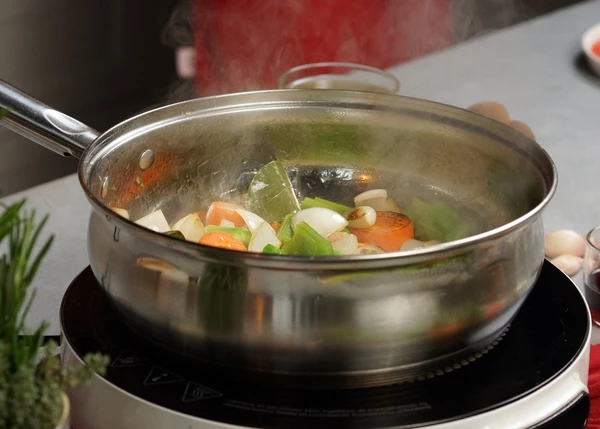 В глубокой сковороде с толстым дном обжарить в течение 3 -4 минут нарезанные овощи с добавлением масла, чеснока и лавра. Переложить все на тарелку.